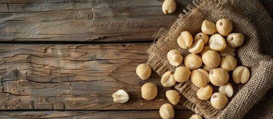 Poster - Macadamia nuts arranged beautifully on a wooden table with copy space image