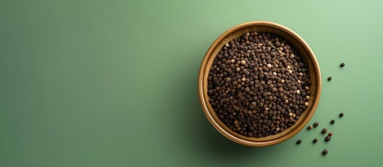Aufkleber - Top view of a bowl filled with ground black pepper on a green surface with copy space image