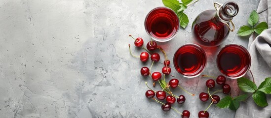 Poster - Cherry liqueur in glasses and a bottle with fresh berries on a light grey table ready for a caption with copy space image