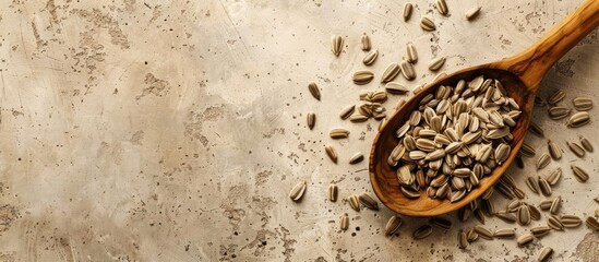 Poster - Beige background with a wooden spoon decorated with sunflower seeds creating a textural copy space image