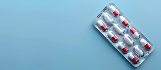 Aufkleber - Top view of antibiotic pills in a blister pack set against a light blue backdrop with room for text in the copy space image