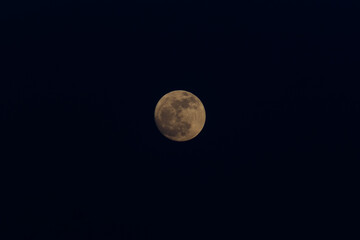 moon closeup showing the details of lunar surface. cloudy sky.
