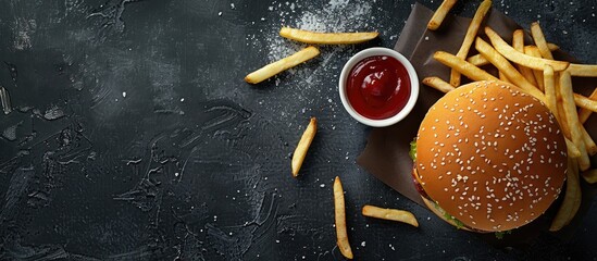 Poster - Top view of a fast food burger menu with fries and ketchup on a black background including a copy space image