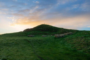 Wall Mural - Beautiful sunrise view on a green hill.