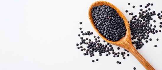 Aufkleber - Black lentil beans with a wooden spoon on a white background. with copy space image. Place for adding text or design
