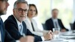 © Jayda_ArtistryHub - Professional business meeting with focused individuals discussing strategies and decisions in a modern conference room.