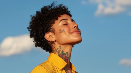 Wall Mural - Smiling woman with curly hair enjoys sunshine against blue sky, expressing joy and contentment. 