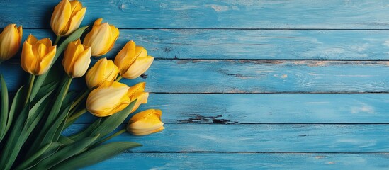Poster - Yellow tulips on a rustic blue wooden table with copy space