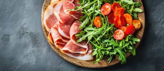 Poster - Fresh pork ham slices on a wooden plate accompanied by arugula salad Gray background Top view Copy space