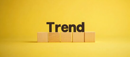Poster - Trend symbol The word Trend on wooden blocks A vibrant yellow background Business and Trend concept Copyspace
