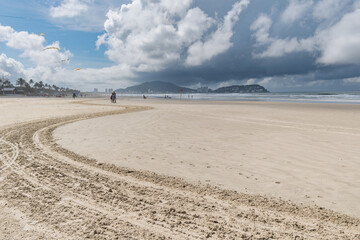 Wall Mural - Morning at Enseada Beach on a beautiful sunny day with some rain clouds around, view of the beach sand and the sea. Guaruja - SP, Brazil.