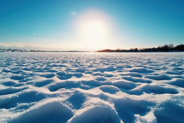 pristine snowy landscape under a bright sun during winter, with untouched snow and a clear blue sky.
