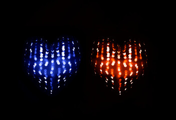 2 two glowing hearts shape with bokeh light. isolated on black background. Valentine's background with many little luminous red blue hearts on black, bokeh effect. 14th february. happy Valentines day