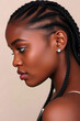 © Janos - A profile portrait of a beautiful black woman with long braided hair, showcasing her elegant features and glowing skin. The background is blurred.