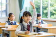 © Big - In the classroom, a little Asian girl raised her hand to answer the teacher's question