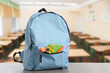© New Africa - Light blue backpack with stationery on school desk in classroom. Space for text
