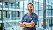 © Adisorn - A smiling healthcare professional stands with arms crossed, wearing a crisp uniform and stethoscope, exuding confidence and competence in a modern hospital setting.
