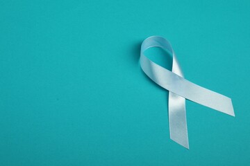 Wall Mural - Prostate cancer awareness. Light blue ribbon on teal background, space for text