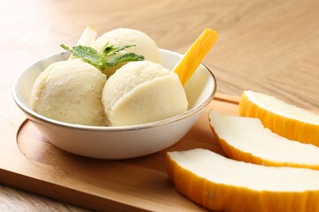 Canvas Print - Scoops of tasty melon sorbet with mint in bowl and fresh fruit on wooden table, closeup