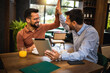 © Mediteraneo - Two colleagues high five in coffee shop. They met to talk about work. Using tablet.