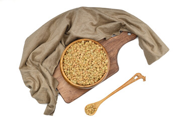 Green lentils in wooden bowl on isolated white background. Top view, copy space. Flat lay.