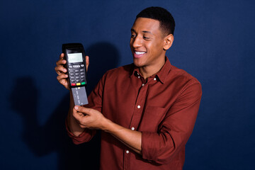 Sticker - Photo of cheerful charming guy dressed brown shirt showing bank card terminal isolated blue color background