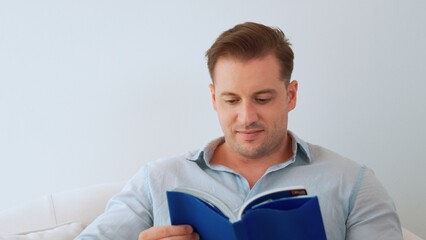 Middle age man sitting on sofa read textbook increase knowledge about social and technology for occupation or raise children to be good adult as smart father. Lifelong learning concept. Divergence.