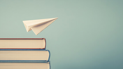 Wall Mural - A paper airplane taking off from a stack of books, symbolizing the flight of ideas and imagination, set against a simple, clean background with soft natural lighting.