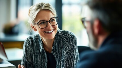 Smiling senior businesswoman discussing with male colleague in meeting at creative office