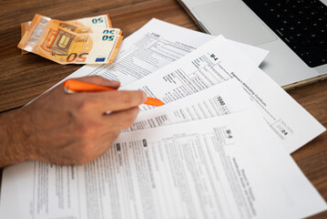 Poster - Man entrepreneur engages in paperwork filling complicated tax forms mandatory for business owners sitting at workplace with euro banknotes and laptop in office