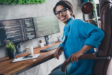 Photo of attractive young woman sit armchair it developer wear blue shirt modern office programmer loft room interior indoors workspace