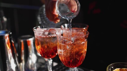 Wall Mural - Bartender working, beautiful row line of different coloured liquor alcohol cocktails on a open air party in a bar, and others on catering banquet on event, barman mixing drinks and beverages in club