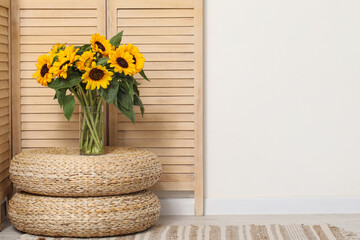 Wall Mural - Vase with beautiful sunflowers on wicker mats near folding screen