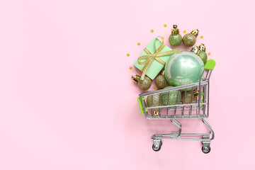 Canvas Print - Small shopping cart with Christmas decor on pink background