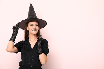 Canvas Print - Young woman dressed for Halloween as witch on light background