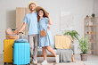 © Pixel-Shot - Young couple of tourists with packed suitcase at home