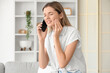 © Pixel-Shot - Young woman with tooth ache talking by phone at home