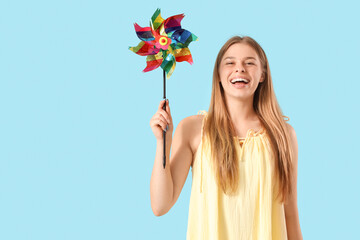 Canvas Print - Young woman with toy windmill on blue background