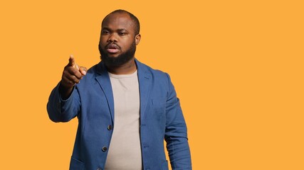 Angry african american man fighting with friend over debacle, isolated over studio background. Rude person in disagreement with mate, swearing and pointing finger, camera A