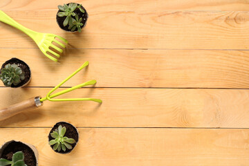 Wall Mural - Gardening tools with rake and plants on beige wooden background. Top view