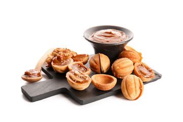 Wall Mural - Slate board with tasty walnut shaped cookies and boiled condensed milk on white background