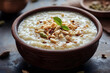 © alfi - Creamy Kheer rice pudding garnished with nuts and cardamom. Traditional dessert served in a rustic bowl.