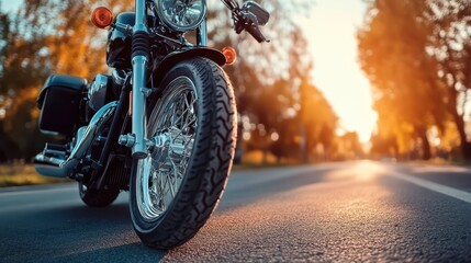 Motorcycle parked on an empty road during a golden sunset