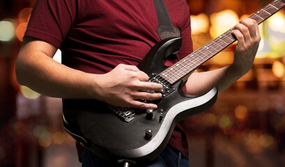 Poster - A guitarist plays on guitar during a band's performance.