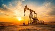 © suphamit - An oil drilling pump jack operating in a desert landscape at sunset