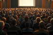 © Eddy Drmwn - A large group of people in an auditorium looking at a screen.