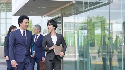 Aufkleber - オフィスビルの前を歩くビジネスパーソンのグループ