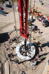 Wall Mural - A crane installs a wind turbine hub onto the tower. The site features various construction tools and equipment