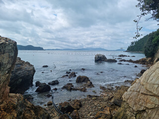 Sticker - 
It is a beach with rocks.