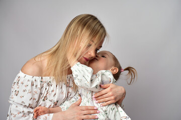 Wall Mural - Portrait of young mother and daughter. Happy woman with child girl. Family portrait on a white background